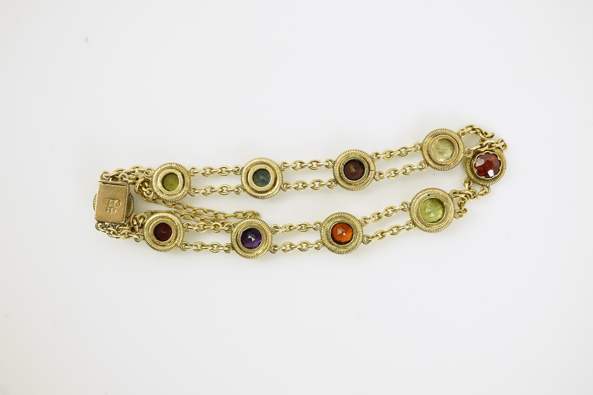 An early 20th century yellow metal and ten stone multi gem set chain link bracelet